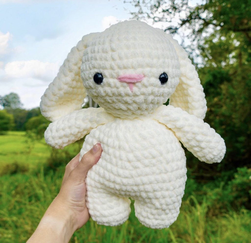 Woman holding a white crochet bunny
